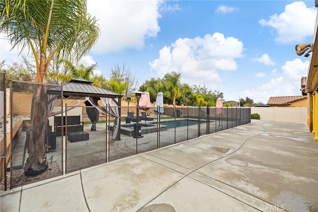 view of swimming pool featuring a gazebo, a patio area, a fenced backyard, and a pool with connected hot tub