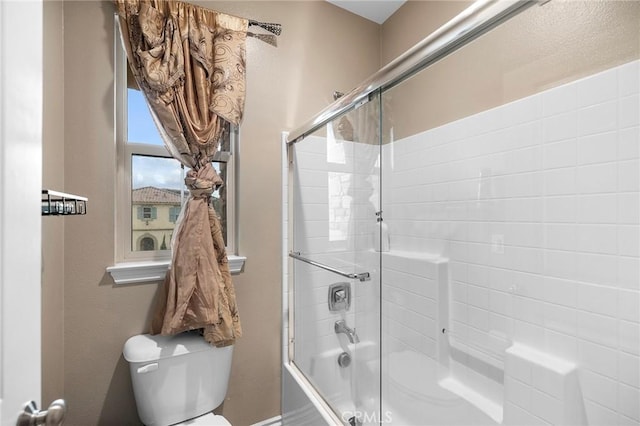 bathroom featuring toilet and enclosed tub / shower combo