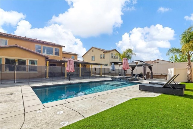 view of pool featuring a pool with connected hot tub, a gazebo, a yard, a fenced backyard, and a patio