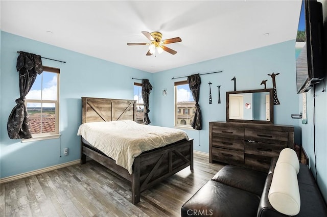 bedroom featuring wood finished floors, baseboards, and ceiling fan