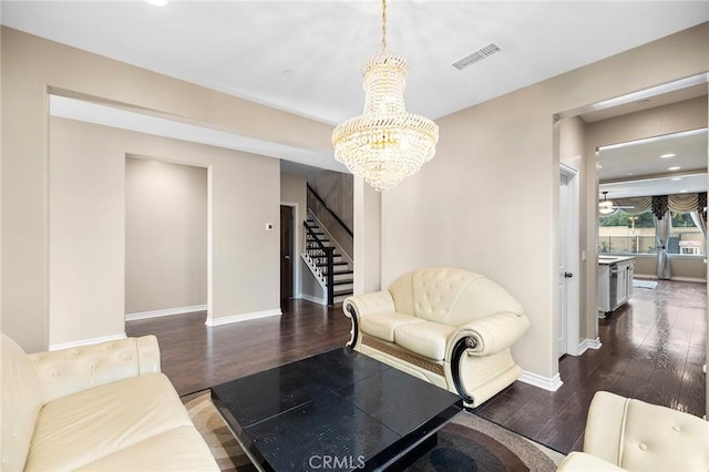 living room with visible vents, stairway, baseboards, and wood finished floors