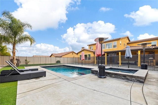 view of swimming pool featuring an in ground hot tub, a fenced in pool, fence, and a patio area