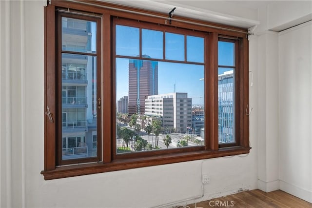 spare room with a view of city and wood finished floors