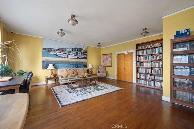 living room with baseboards, wood-type flooring, and ornamental molding