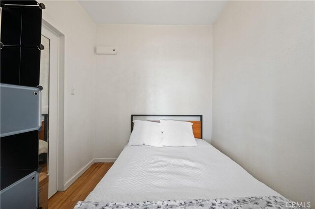 bedroom featuring baseboards and light wood-style floors