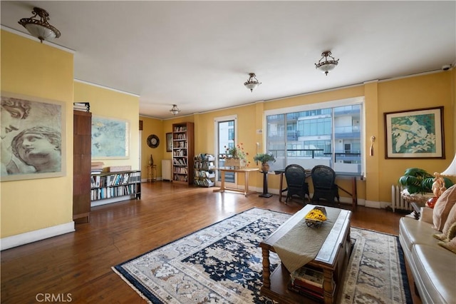 living room with radiator, wood finished floors, and baseboards