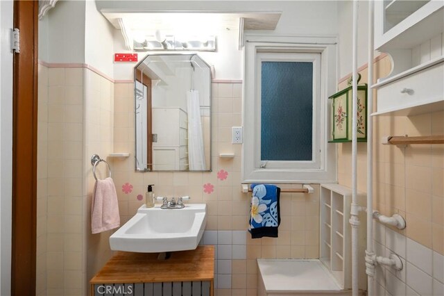 bathroom featuring tile walls and a sink