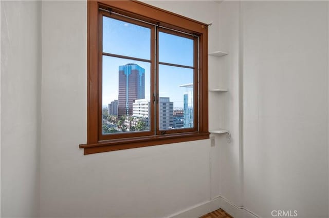 unfurnished room with a view of city and baseboards