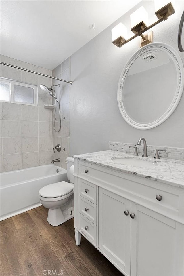 12899 Rain Shadow Rd, Victorville, CA 92395 - full bathroom featuring visible vents, toilet, wood finished floors, vanity, and  shower combination