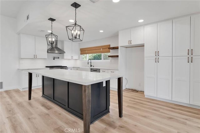 12899 Rain Shadow Rd, Victorville, CA 92395 - kitchen featuring a kitchen island, wall chimney range hood, pendant lighting, light wood-style floors, and white cabinets