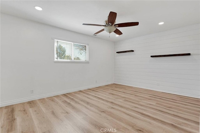 12899 Rain Shadow Rd, Victorville, CA 92395 - unfurnished room with a ceiling fan, baseboards, recessed lighting, light wood-style floors, and wood walls