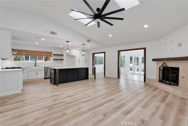 12899 Rain Shadow Rd, Victorville, CA 92395 - kitchen with visible vents, a fireplace with raised hearth, a sink, stainless steel dishwasher, and open floor plan