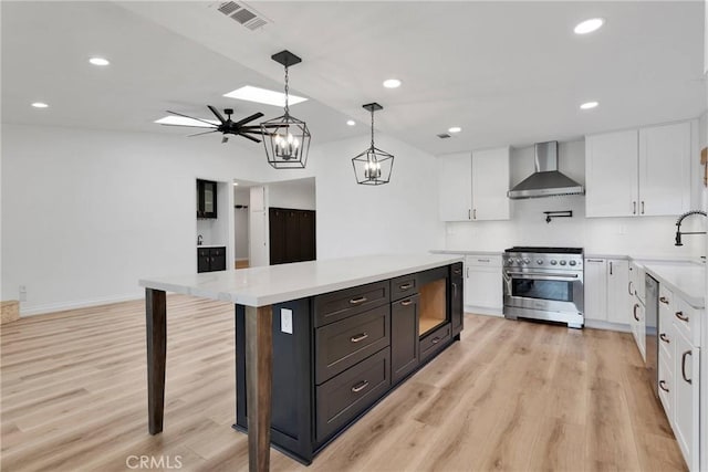 12899 Rain Shadow Rd, Victorville, CA 92395 - kitchen with wall chimney range hood, stainless steel appliances, light wood-style floors, white cabinets, and light countertops