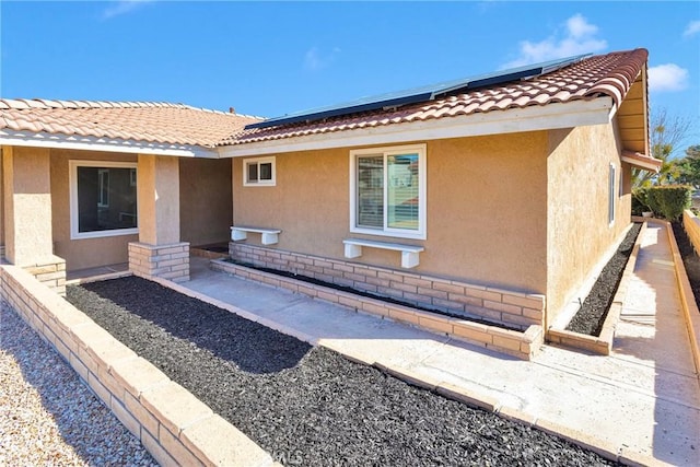 12899 Rain Shadow Rd, Victorville, CA 92395 - exterior space featuring stucco siding, roof mounted solar panels, and a tile roof