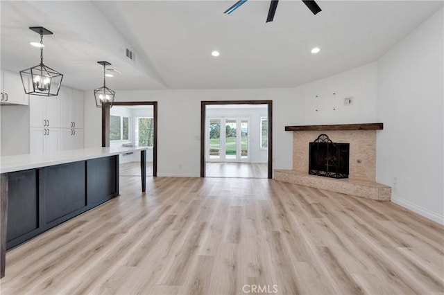 12899 Rain Shadow Rd, Victorville, CA 92395 - unfurnished living room with a fireplace with raised hearth, light wood-style floors, and lofted ceiling
