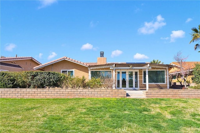 12899 Rain Shadow Rd, Victorville, CA 92395 - back of property with stucco siding, a lawn, and a chimney