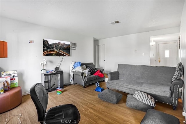 living room featuring visible vents, a textured ceiling, and wood finished floors