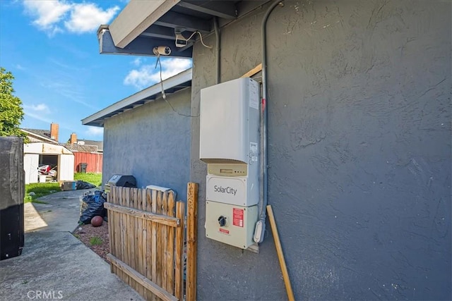 view of side of home with stucco siding and an outbuilding