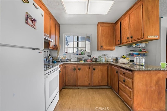 kitchen featuring white appliances, brown cabinetry, light wood-style floors, and stone countertops