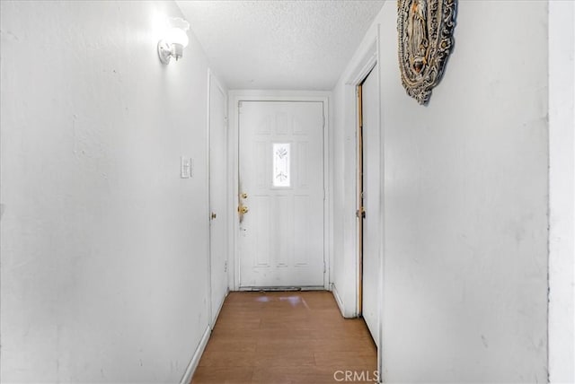 entryway featuring light wood-style flooring and a textured ceiling