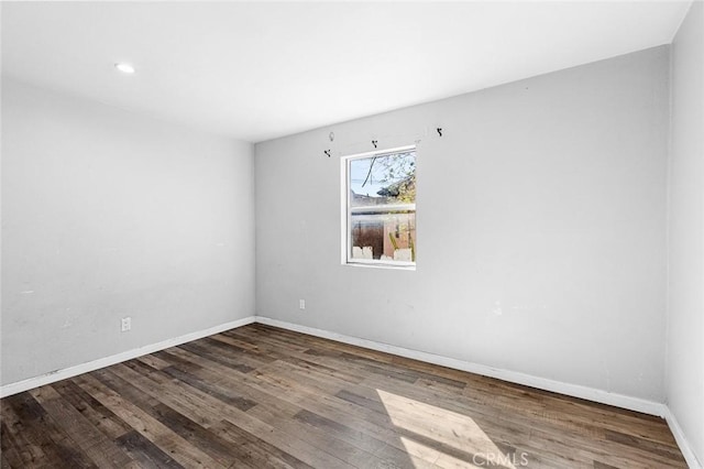 empty room with baseboards and wood finished floors