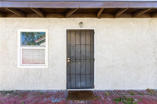 doorway to property featuring stucco siding