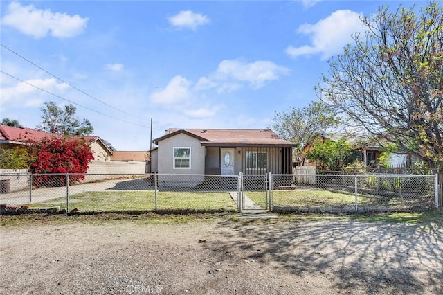 view of front of property with a fenced front yard, stucco siding, and a gate