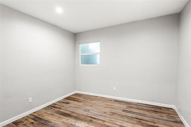 empty room with wood finished floors and baseboards