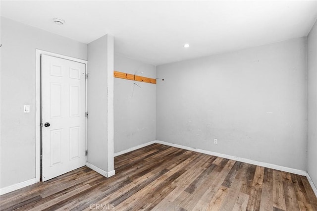 spare room featuring wood finished floors and baseboards