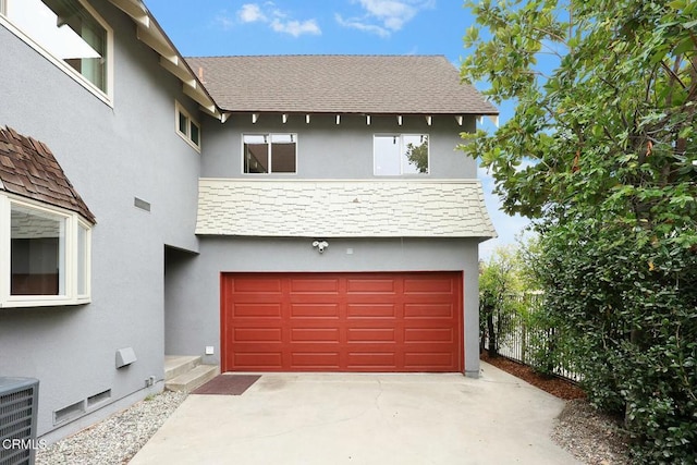 garage featuring concrete driveway and cooling unit