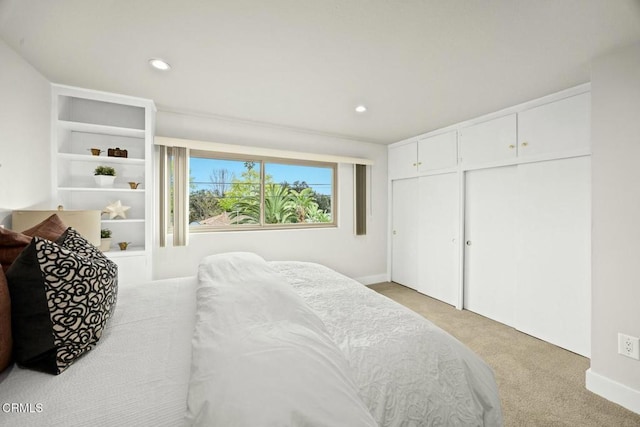 bedroom with recessed lighting, a closet, and light carpet