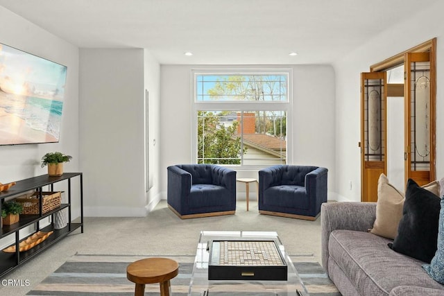 carpeted living area with recessed lighting and baseboards