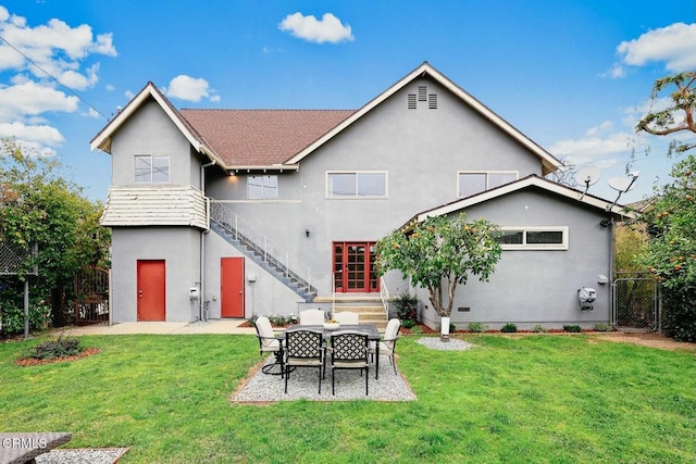 rear view of house featuring a yard, a patio area, stairs, and stucco siding