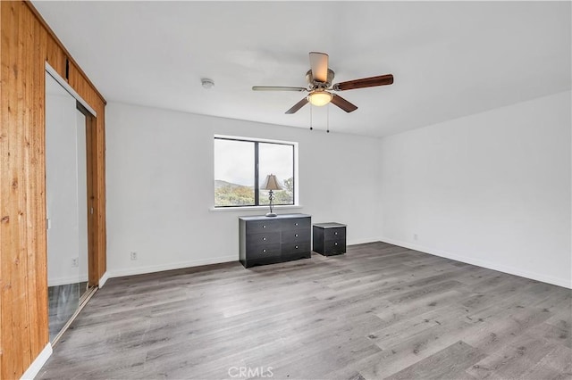 interior space with ceiling fan, baseboards, and wood finished floors