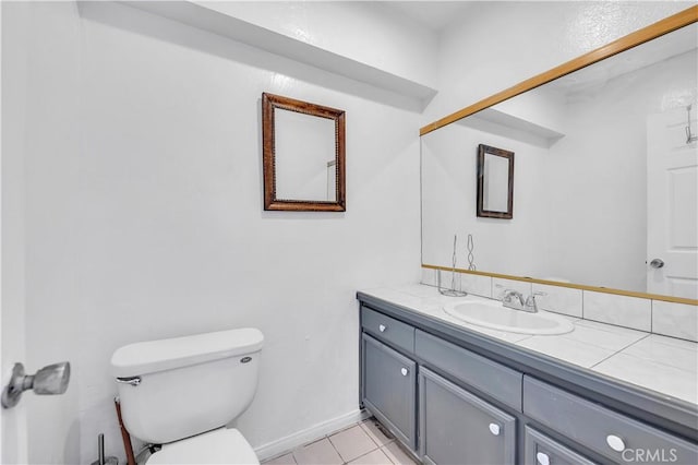 bathroom featuring tile patterned flooring, toilet, vanity, and baseboards