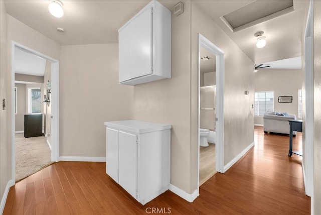 hallway featuring baseboards and wood finished floors