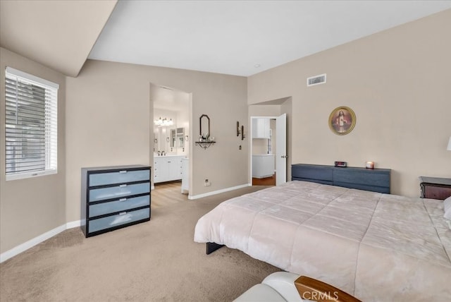 carpeted bedroom featuring visible vents, connected bathroom, lofted ceiling, and baseboards