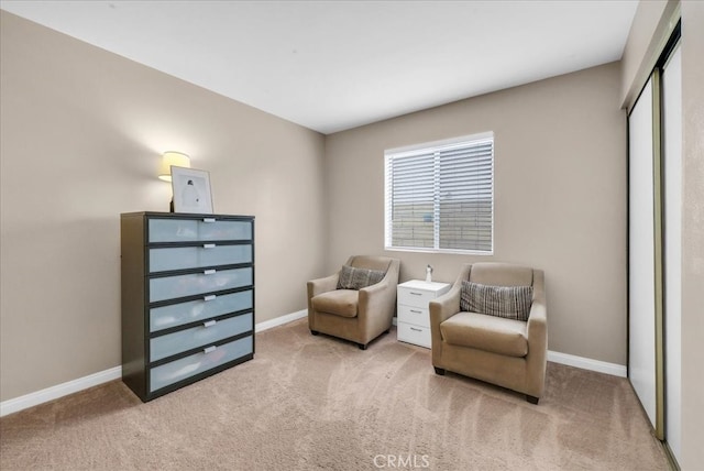 sitting room with baseboards and carpet floors