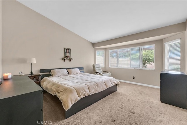 carpeted bedroom with baseboards and vaulted ceiling