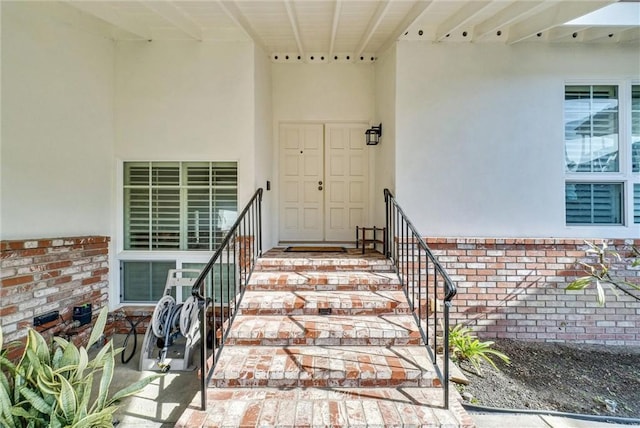 property entrance featuring brick siding and stucco siding