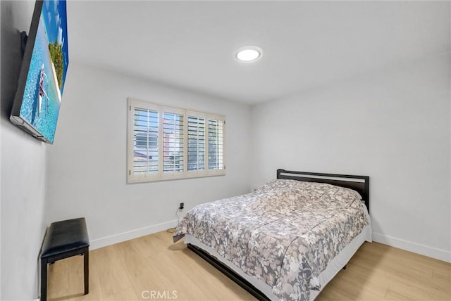 bedroom featuring baseboards and wood finished floors