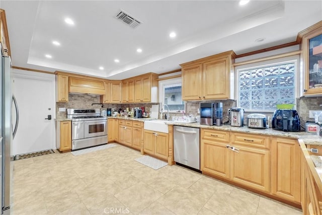 kitchen featuring a raised ceiling, visible vents, appliances with stainless steel finishes, and a sink