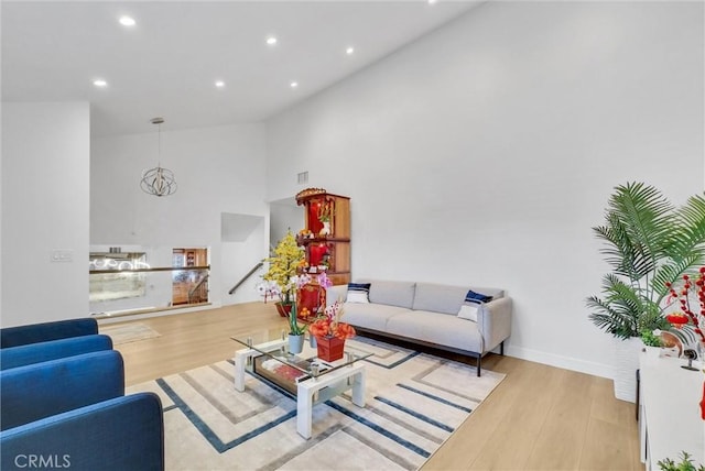 living area with visible vents, high vaulted ceiling, wood finished floors, recessed lighting, and baseboards