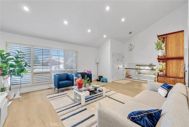 living area with recessed lighting, light wood-style floors, and high vaulted ceiling