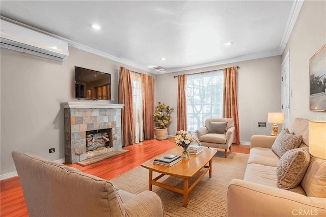 living room featuring crown molding, a fireplace, a wall mounted AC, and wood finished floors