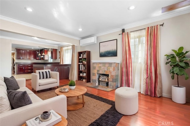 living area featuring an AC wall unit, recessed lighting, light wood-style floors, crown molding, and a dry bar