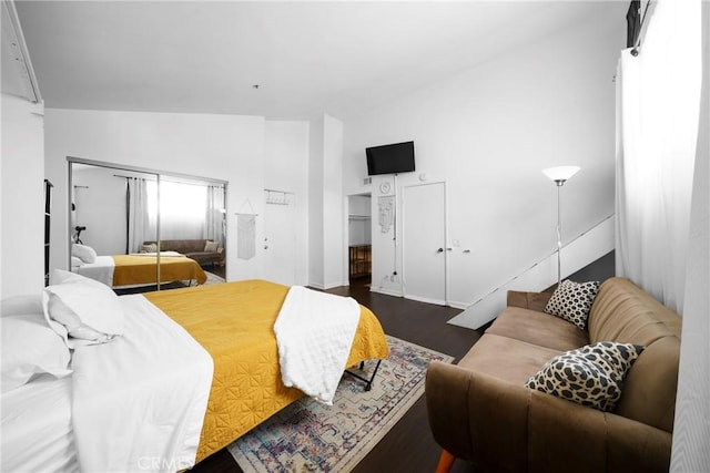 bedroom featuring high vaulted ceiling and dark wood-type flooring