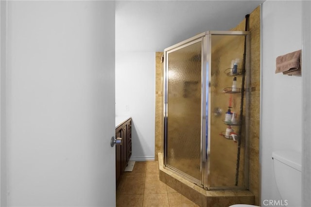 bathroom with tile patterned flooring, a shower stall, toilet, and vanity