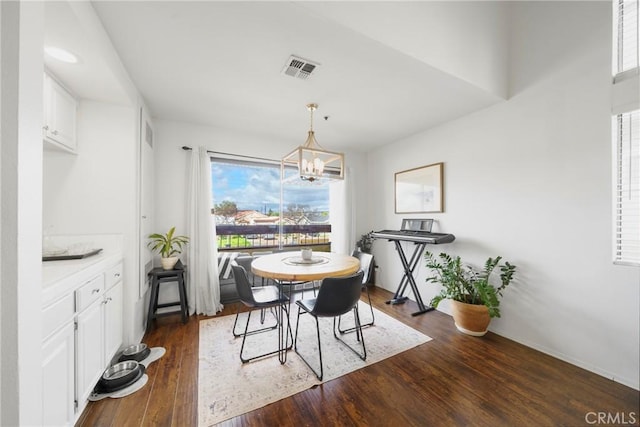 dining room featuring visible vents, a notable chandelier, and dark wood-style floors