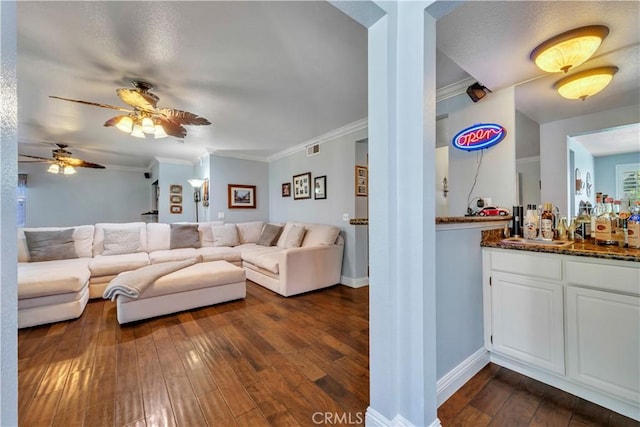 living area featuring visible vents, ornamental molding, baseboards, and dark wood-style flooring